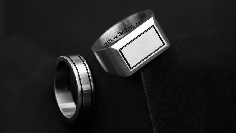 Premium 316L stainless steel rings collection on black background.